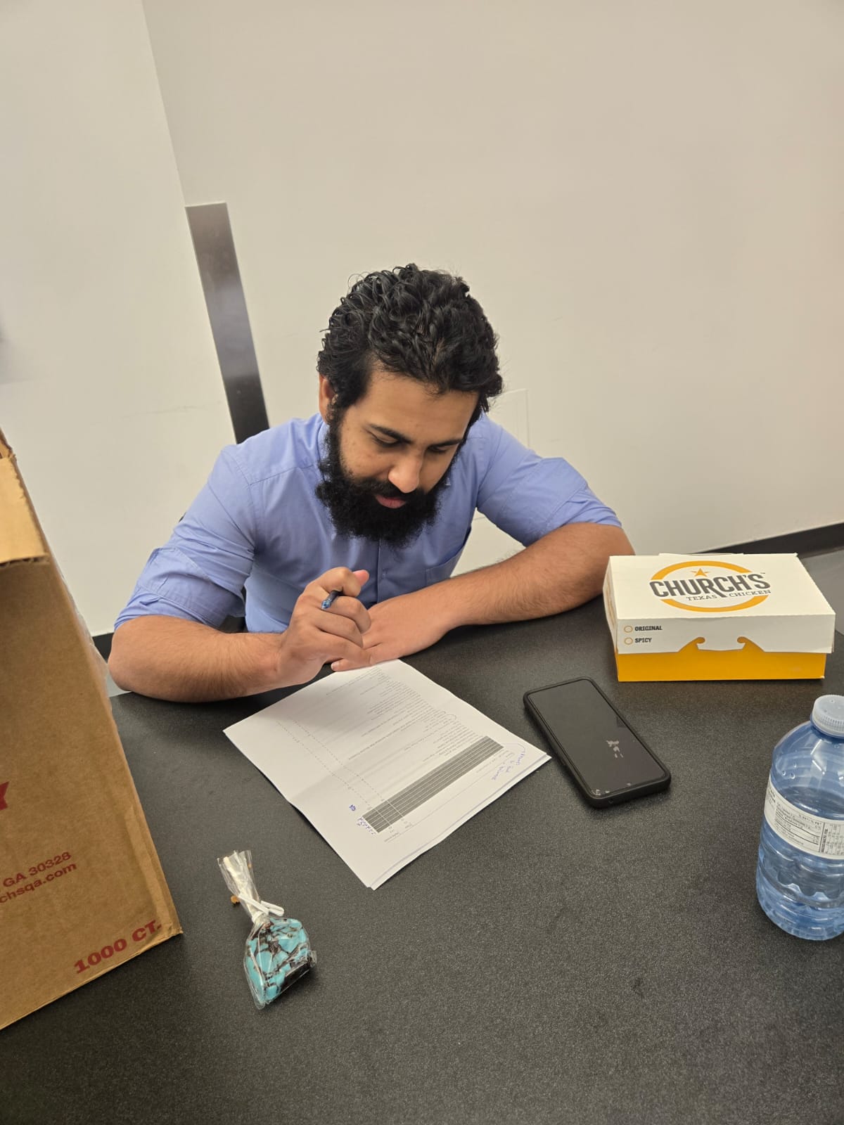 Muhammad working through printed research material during the thematic analysis process.